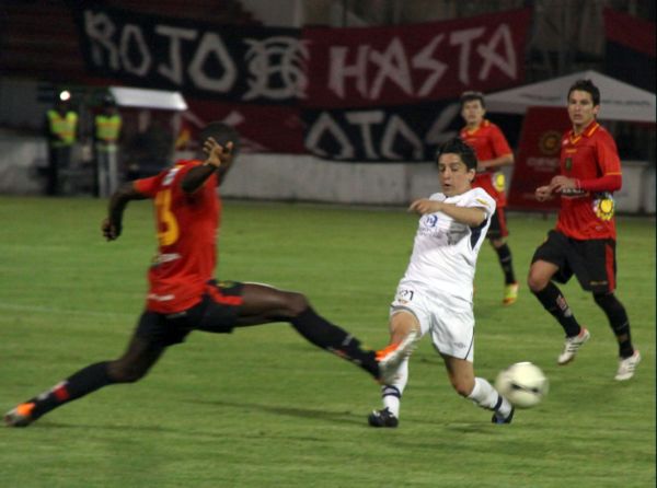 Henrry Cangá intenta arrebatarle la pelota Damián Manso de Liga de Quito.