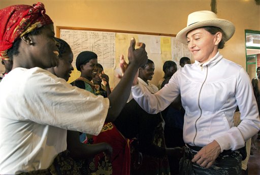 Madonna, centro, saluda a una voluntaria durante un recorrido por el orfanato Mphandura cerca de Lilongüe, Malaui, el viernes 5 de abril de 2013. (Foto AP/Thoko Chikondi)