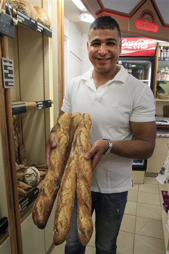 Ridha Khadher, un panadero tunecino en su panadería de París con algunas de sus baguette, el viernes 26 de abril del 2013. (Foto AP/Remy de la Mauviniere)