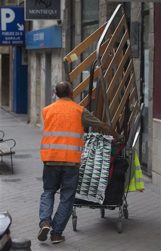 Un hombre empuja un carro con chatarra en Madrid el viernes, 26 de abril del 2013. España espera reducir su déficit presupuestario al 3%, límite marcado por la Unión Europea, para fines del 2016, dos años después de lo prometido. (Foto AP/Paul White)
