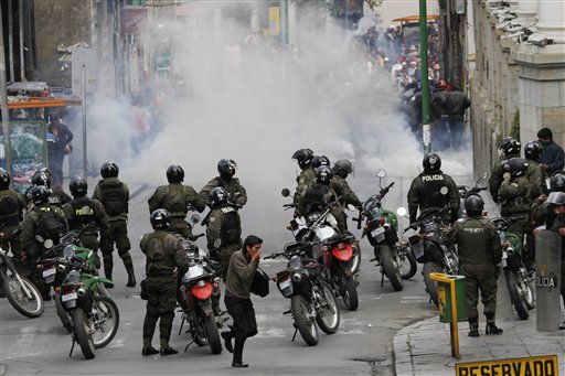 Policías se protegen de sus prpios gases lacrimógenos lanzados para dispersar una marcha de mineros en una protesta callejera en La Paz, Bolivia, el jueves 16 de mayo 2013. (AP Photo/Juan Karita)