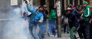 Un manifestante devuelve un casquillo de bomba de gas lacrimógeno  la policía en una protesta callejera en La Paz, Bolivia, el jueves 16 de mayo 2013. (AP Photo/Juan Karita)