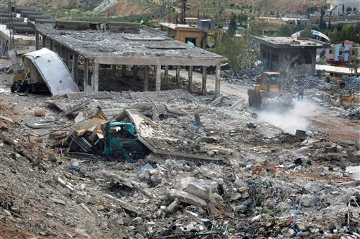 En esta foto del 5 de mayo del 2013 sumiistrada por la agencia noticiosa oficial siria SANA, los trabajadores despejan los escombros de edificios destruidos por un ataque aéreo israelí en Damasco, Siria (AP Foto/SANA, Archivo)