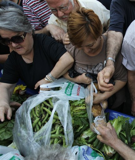 La gente se empuja para conseguir verduras mientras vendedores reparten comida gratis durante una protesta en Atenas el miércoles 15 de mayo de 2013. (Foto de AP/Thanassis Stavrakis)