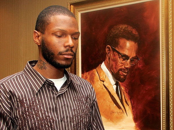 Malcolm Shabazz junto a un cuadro de su abuelo el activista Malcolm X