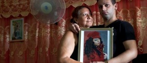 Dayan Sánchez, 25, derecha, un gay un artista travesti conocido como "Venus" posa con su madre Anadelia Morales, 47, en su casa en La Habana, Cuba. Una semana de desfiles, espectáculos y eventos culturales gays concluyó el viernes 18 de mayo de 2013. (AP Photo/Ramon Espinosa)