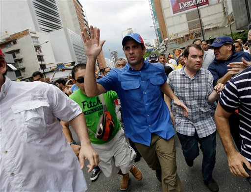 El dirigente opositor Henrique Capriles saluda a sus partidarios durante una marcha del Primero de Mayo en Caracas. Las autoridades electorales iniciaron el lunes el proceso de auditoría complementaria de las elecciones del 14 de abril sin la presencia de la oposición, que rechazó participar en la revisión alegando que no fueron incluidos todos los elementos del proceso. (AP Foto/Fernando Llano)