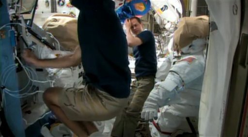 Los astronautas estadounidenses Chris Cassidy, al frente, y Tom Marshburn se preparan el viernes 10 de mayo de 2013 para una caminata espacial prevista para el sábado en la Estación Espacial Internacional. Intentarán reparar una fuga de amoniaco del mecanismo de refrigeración del sistema de electricidad de la estructura espacial. (AP Foto/NASA)
