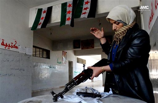 Esta imagen de periodismo ciudadano del martes 14 de mayo de 2013, proporcionada por el Aleppo Media Center AMC y cuya autenticidad ha sido verificada en base a su contenido y otra labor periodística de la AP, muestra a la madre de un insurgente sirio que limpia un fusil, en Alepo, Siria. (Foto AP/Aleppo Media Center AMC)