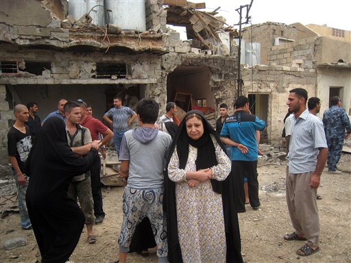 Residentes reaccionan luego de la explosión de un coche bomba en Kirkuk, 290 kilómetros al norte de Bagdad, Irak, el miércoles, 15 de mayo del 2013. Al menos 33 personas murieron en todo el país en ataques con bombas, dijeron las autoridades. (Foto AP/Emad Matti)