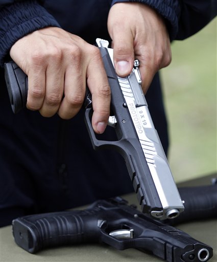 En esta fotografía del 29 de abril de 2013 un empleado sostiene un prototipo de la nueva pistola "Córdova" producida por la estatal Industria Militar en Soacha, Colombia. La pistola 9 milímetros saldrá al mercado en los primeros días de junio. (AP foto/Fernando Vergara)
