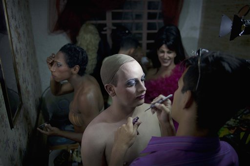 En esta foto del 15 de mayo de 2013 photo, Gilberto Diez, derecha, aplica maquillaje a Dayan Sanchez, 25, un gay artista travesti conocido como "Venus" preparándose para un espectáculo sobre moda en La Habana, Cuba. Una semana de desfiles, espectáculos y eventos culturales gays concluyó el viernes 18 de mayo de 2013. (AP Photo/Ramon Espinosa)
