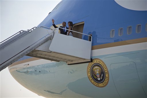 El presidente de Estados Unidos Barack Obama y su esposa Michelle saludan antes de abordar el avión presidencial en la Base Andrews de la Fuerza Aérea, en Maryland, el miércoles 26 de junio de 2013, antes de viajar a Senegal, Sudáfrica, y Tanzania. (Foto AP/Evan Vucci)