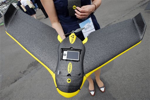 Personal de la empresa Sensefly muestran un avión teledirigdo ultraligero eBee de uso civil profesional y que permite tomar fotografías y video, durante la edición 50 de la Exhibición Aérea de París en el aeropuerto de Le Bourget, al norte de París, el martes 18 de junio de 2013. (Foto AP/Francois Mori)