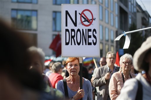 Una manifestante sostiene un cartel contra el uso militar de aviones no tripulados durante una protesta previo a la visita del presidente estadounidense Barack Obama a Berlín en una gira de dos días a la capital alemana, el lunes 17 de junio de 2013. (Foto AP/Markus Schreiber)