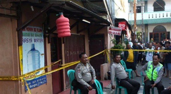 Foto del viernes, 3 de mayo del 2013 muestra a varios agentes frente a la casa de Sefa Riano, presunto islamista detenido tras publicar sus planes de detonar una carga explosiva en la embajada de Mianmar en su página de Facebook, en Yakarta, Indonesia. (Foto AP/Dita Alangkara)
