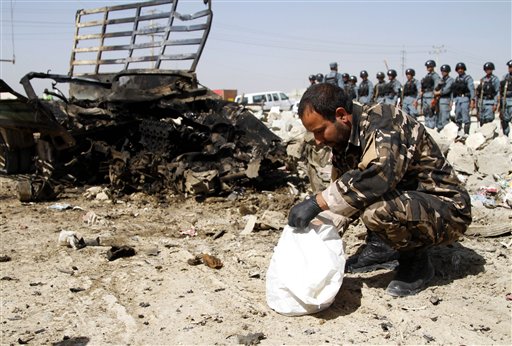 Un oficial de seguridad e inteligencia afgana inspecciona el lugar de un atentado suicida cerca del aeropuerto militar de Kabul en Afganistán el lunes 10 de junio de 2013. (Foto AP/Ahmad Jamshid)