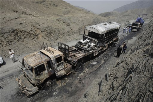 Personal de seguridad de Pakistán y pobladores de aldeas vecinas observan los camiones de un convoy de la OTAN destrudos en un ataque de milicianos disfrazados de policías en la región de Khyber el lunes 10 de junio del 2013. Un funcionario paquistaní dijo que ataques con cohetes destruyeton camiones de suministro de la OTAN y causaron la muerte a varias personas. (Foto AP/Mohammad Sajjad)