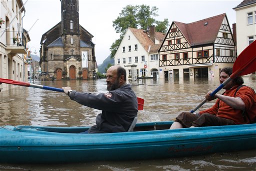 Dos hombres reman por una zona comercial inundada por el río Elba, el martes 4 de junio de 2013 en Wehlen, Alemania. (Foto AP/Markus Schreiber)