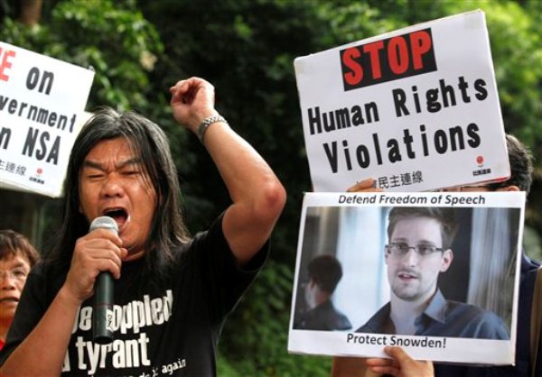 Varios manifestantes empuñan fotos de Edward Snowden, un ex empleado de la CIA que filtró información secreta sobre el espionaje estadounidense, frente al consulado de Estados Unidos en Hong Kong el jueves, 13 de junio del 2013. (Foto AP/Kin Cheung)