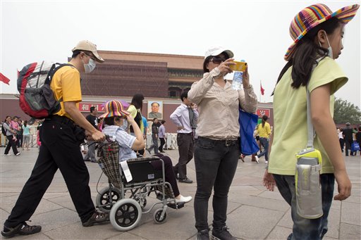 Visitantes de la plaza Tiananmen se protegen con un cubrebocas de la fuerte contaminación en Beijing, el 7 de mayo de 2013. Un estudio dado a conocer el 9 de julio de 2013 vincula la densa contaminación ambiental por la quema de carbón con una menor esperanza de vida en el norte de China. (Foto AP/Ng Han Guan)