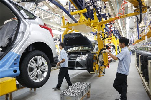 En esta fotografía del lunes 27 de agosto de 2012 proporcionada por Ford Motor Co., un par de trabajadores ensamblan un automóvil en la nueva planta Ford/CFMA Chongqing tras su inauguración en Chongqing, China. (Foto AP/Ford Motor Co.)