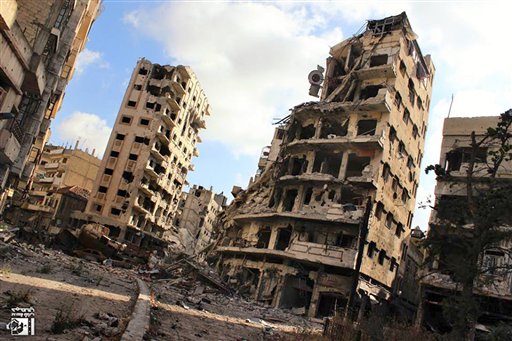 Numerosos edificios están destruidos debido a los ataques del gobierno sirio contra el vecindario de Jouret al-Chiyah en Homs, Siria, el miércoles 3 de julio de 2013. Unos 2.500 civiles están atrapados en Homs, donde el ejército pretende expulsar a los rebeldes. (AP Foto/Lens Young Homsi)
