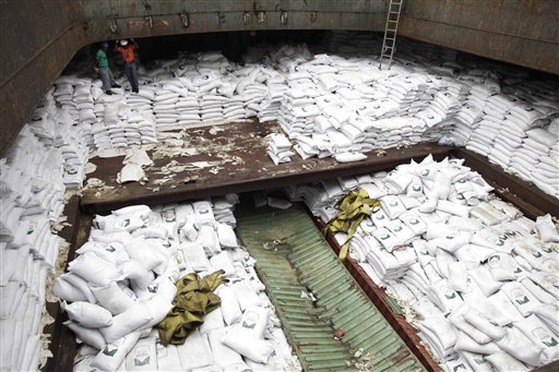 Trabajadores panameños de pie sobre sacos de azúcar debajo de los cuales se encontraron armas en un barco de Corea del Norte. El barco fue retenido en la terminal internacional de contenedores de Manzanillo en la costa de Colón, Panamá, el martes 16 de julio de 2013. (Foto AP Photo/Arnulfo Franco)