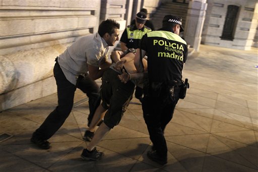 Policías arrestan a un manifestante durante una protesta contra el gobierno frente a las oficinas centrales del Partido Popular, el jueves 18 de julio de 2013, en Madrid, España. (Foto AP/Andrés Kudacki)