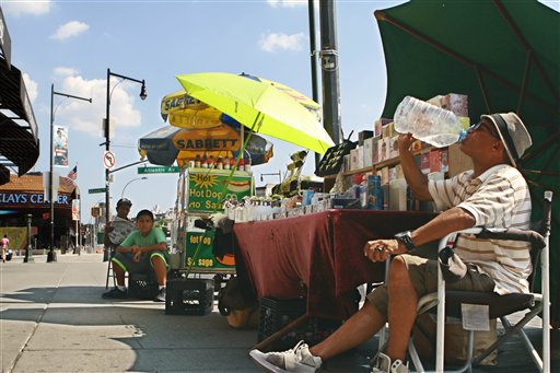 En medio de una feroz ola de calor, Robert Llambelis toma agua en su puesto callejero de ventas en Brooklyn, Nueva York, el 18 de julio del 2013. La ola de calor hace que se consuma mucha energía y obliga al consumidor a buscar formas de disminuir el consumo. (AP Photo/Jon Gerberg)