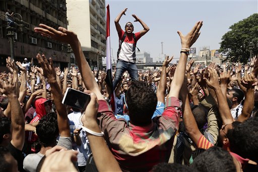 Simpatizantes del depuesto presidente de Egipto, Mohammed Morsi, corean lemas contra el ministro de defensa egipcio, el general Abdel-Fattah el-Sissi antes de los enfrentamientos con las fuerzas de seguridad en la Plaza Ramses, en el centgro de El Cairo, la capital egipcia el viernes 16 de agosto del  2013. Varias empresas internacionales que operan en Egipto suspendieron sus operaciones durante los tres días de violentos disturbios callejeros que crearon una situación de inseguridad pública en El Cairo.  (Foto AP/Hassan Ammar)