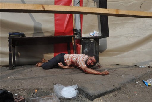 Un partidario del presidente islamista depuesto Mohamed Morsi yace en el suelo luego de que las fuerzas de seguridad despejaron un campamento de protesta cerca de la Universidad de El Cairo en el distrito de Giza. El operativo del 14 de agosto de 2013 dejó más de 500 muertos. (Foto AP/Hussein Tallal)