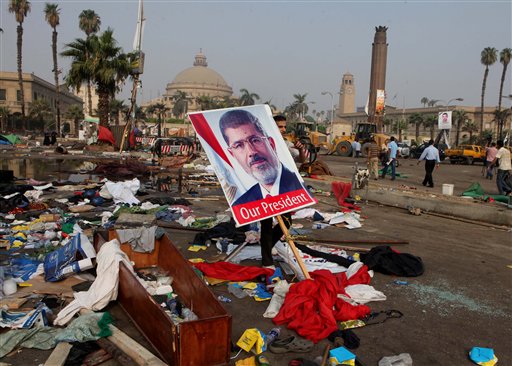 Un cartel con la imagen del ex presidente egipcio Mohammed Morsi está entre los escombros que quedaron tras el desalojo de un campamento en la plaza Nahda, en El Cairo, el jueves 15 de agosto de 2013. (Foto AP/Amr Nabil)