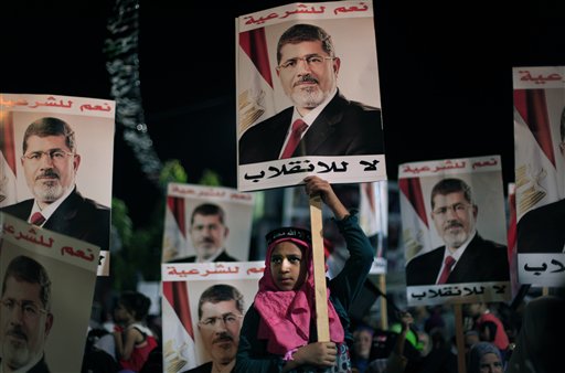 Simpatizantes del presidente egipcio derrocado Mohamed Morsi  sostienen carteles con texto en árabe que lee "Sí a la legalidad, no al golpe de Estado", durante una protesta afuera de la mezquita Rabaah al-Adawiya, donde los manifestantes han instalado un campamento y sostenido marchas diarias en Nasr City, en el Cairo, Egipto, el martes 6 de agosto de 2013. Más de 10 días de esfuerzos diplomáticos para hallar la forma de resolver el estancamiento en que cayeron la Hermandad Musulmana y el gobierno interino respaldado por el ejército han fracasado, afirmó el miércoles 7 de agosto la presidencia. (Foto AP/Khalil Hamra)