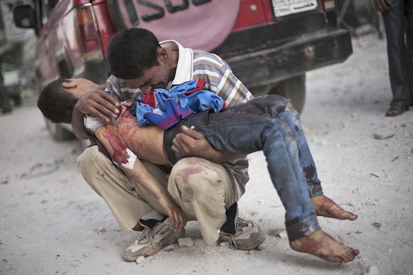 ARCHIVO- En esta foto de archivo del 3 de octubre de 2012, un hombre llora mientras sostiene el cuerpo de su hijo, asesinado por el ejército sirio, cerca del hospital Dar El Shifa en Alepo, Siria. El secretario general de las Naciones Unidas Ban Ki-moon dijo el jueves 25 de julio de 2013 que la cifra total de muertos en los dos años y medio de guerra civil en Siria se elevó a más de 100.000. (AP Foto/Manu Brabo, Archivo)