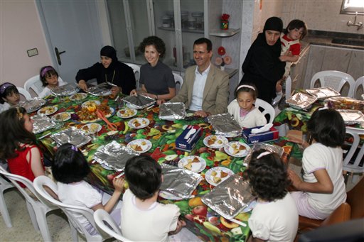 El presidente sirio Bashar Assad (centro) con su esposa, Asma (centro izquierda) comparten la mesa con huérfanos cristianos en el Convento de Santa Tecla en Maaloula, unos 60 kilómertros al noreste de Damasco, en una imagen de 27 de abril de 2008. (Foto AP/Bassem Tellawi, Archivo)