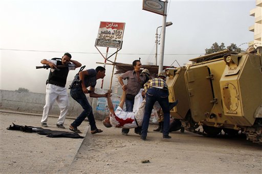 Fuerzas de seguridad egipcias cargan el cadáver del jefe de la policía de Guiza, general Nabil Farag, centro, quien murió cuando combatientes no identificados dispararon contra los efectivos desplegados la mañana del jueves 19 de septiembre de 2013 en el poblado de Kerdasa para expulsar a presuntos islamistas que se apoderaron de la ciudad cercana a las pirámides de Guiza, en Egipto. (Foto AP/Ahmed Abdel Fattah)