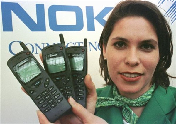 Tania Stefezius sostiene varios teléfonos móviles Nokia 3100 en la muestra CeBUT de 1997 en Hanover, Alemania, en una imagen del 12 de marzo de 1997. Nokia, la otrora estrella de los móviles y orgullo nacional de Finlandia, quedó estremecida el martes 3 de septiembre por la noticia de que  Microsoft Corp. comprará sus operaciones de telefonía móvil. (Foto AP/Fabian Bimmer, archivo)