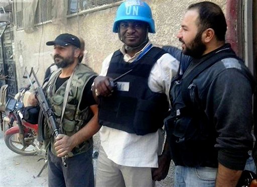 Un miembro del equipo de investigadores de la ONU es escoltado por los rebeldes sirios en Zamalka, una ciudad de las afueras de Damasco, Siria, el miércoles 28 de agosto del 2013, en una foto tomada por un periodista ciudadano cuyo contenido ha sido verificado. En lo que respecta a Siria, el gobierno del presidente Barack Obama está seguro de algo:  El gobierno de su homólogo Bashar Assad debe recibir castigo después que presuntamente usó armas químicas, posiblemente gas sarín, para matar a cientos de sirios. (Foto AP/Oficina de United media de Arbeen)