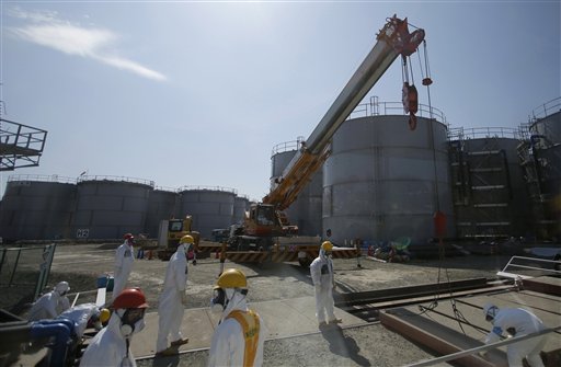 Trabajadores de la operadora Tokyo Electric Power Co. trabajan cerca de tanques de agua radiactiva en la planta nuclear de Fukushima Dai-ichi, en Japón, el 6 de marzo de 2013. El operador de Fukushima, dañada por un sismo y tsunami hace dos años, no ha podido evitar que contaminada se siga filtrando al mar, se informó el martes 6 de agosto de 2013. (Foto AP/Issei Kato, Pool, Archivo)