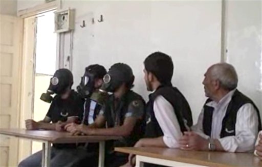 Esta imagen tomada de un video de la AP publicado el miércoles 18 de septiembre de 2012, muestra a estudiantes en Alepo, Siria, con máscaras antigás durante una sesión informativa sobre cómo actuar durante un ataque con armas químicas. (Foto AP vía AP video)