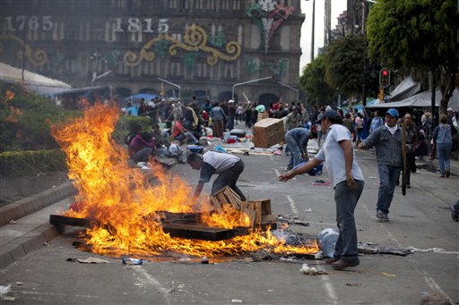 Maestros inconformes prenden fuego a cosas en el Zócalo, la principal plaza de la Ciudad de México, el viernes 13 de septiembre de 2013, en momentos de tensión por un posible enfrentamiento con la policía antidisturbios. (AP Foto/Eduardo Verdugo)