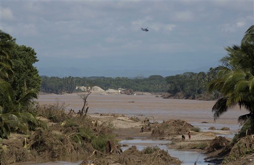 Un helicóptero de la policía federal sobrevuela un río del sur de Acapulco, Guerrero, el miércoles 18 de septiembre de 2013.  Dos tormentas golpearon el estado de guerrero, provocaron deslaves e inundaciones. El número de muertos es 80. (AP foto/Eduardo Verdugo)
