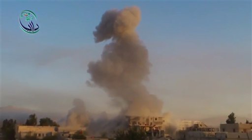 En esta imagen tomada de un video obtenido por Shaam News Network, que ha sido verificada sobre la base de su contenido y reportes de la AP, se ve una columna de humo ascender de edificios tras la explosión de una bomba en Daraya, en las afueras de Damasco, el martes, 15 de octubre del 2013. (Foto AP/Shaam News Network via AP Video)