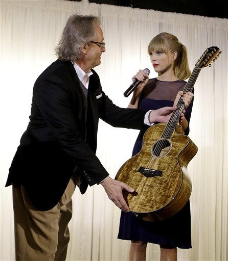 Taylor Swift entrega una guitarra para exhibición a Kyle Young, en el Museo y Salón de la Fama de la Música Country el sábado 12 de octubre de  2013, en Nashville, Tenesí. Swift inauguró en el museo el Centro Educativo Taylor Swift cuyo costo fue de 4 millones de dólares. (Foto AP/Mark Humphrey)