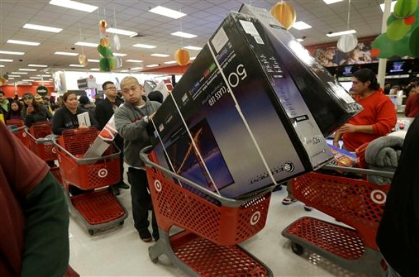 Un hombre lleva dos pantallas de televisión en un carrito de compras en una tienda Target en Colma, California, en el Día de Acción de Gracias, el jueves 28 de noviembre de 2013. Muchas tiendas abrieron este día y siguieron funcionando el Viernes Negro, al inicio de la temporada de compras de fin de año. (AP Foto/Jeff Chiu)
