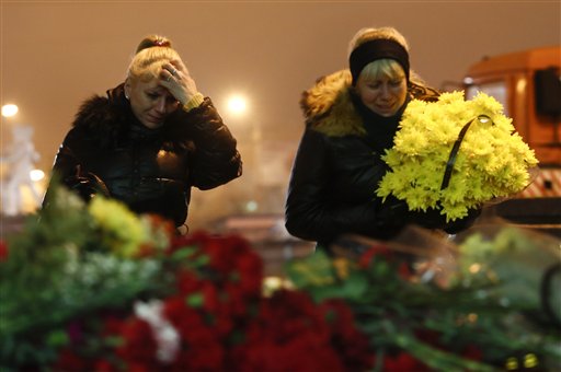 Dos mujeres lloran al colocar flores frente a la principal estación ferroviaria de Volgogrado, Rusia, el 30 de diciembre de 2013. 
