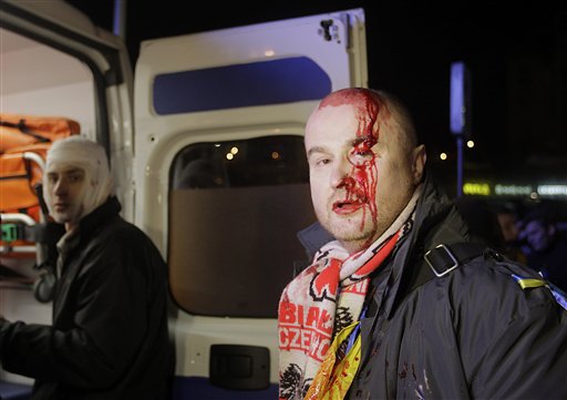Un par de manifestantes reciben atención médica en una ambulancia tras ser agredidos por agentes de la policía antidisturbios en un intento por disolver una protesta que exige la renuncia del presidente Viktor Yanukovych, en la Plaza de la Independencia en el cento de Kiev, capital de Ucrania, el sábado 30 de noviembre de 2013. (Foto AP/Sergei Chuzavkov)