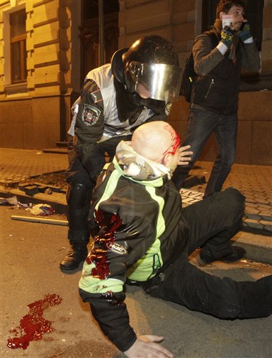 Un rescatista de la policía ayuda a un manifestante que resultó herido en el enfrentamiento entre opositores al gobierno de Ucrania y ciudadanos que protestaron contra la decisión del gobierno de no firmar un acuerdo comercial con la Unión Europea ocurrido el domingo 1 de diciembre de 2013. (Foto de AP/Sergei Chuzavkov)