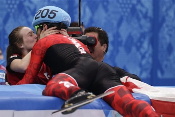 *El canadiense Charles Hamelin (derecha) besa a Marianne St. Gelais tras ganar la medalla de oro en los 1.500 metros del patinaje en pista corta de los Juegos Olímpicos de Invierno. (AP Foto/Darron Cummings)